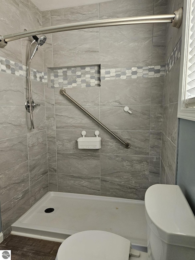 bathroom with toilet and a stall shower