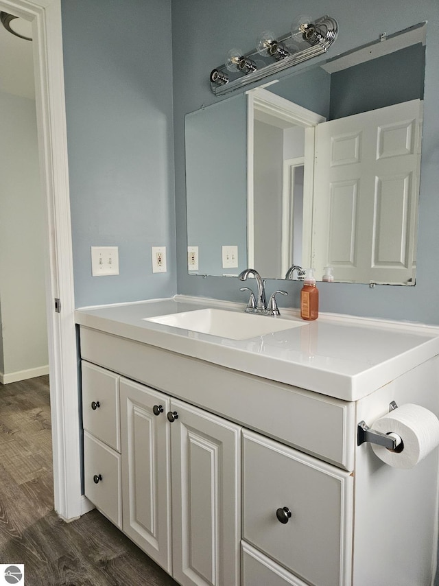 bathroom with vanity, baseboards, and wood finished floors