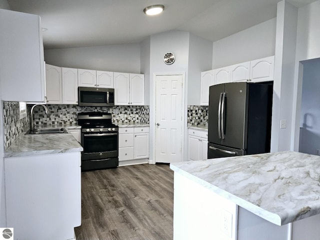 kitchen with a sink, appliances with stainless steel finishes, white cabinets, light countertops, and lofted ceiling