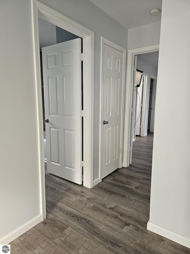 hallway with baseboards and dark wood-style floors