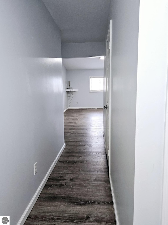 hall featuring dark wood-style floors and baseboards