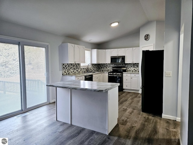 kitchen featuring tasteful backsplash, white cabinets, dark wood finished floors, and black appliances