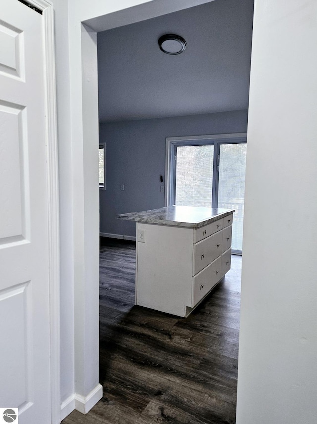 hall featuring dark wood-type flooring and baseboards