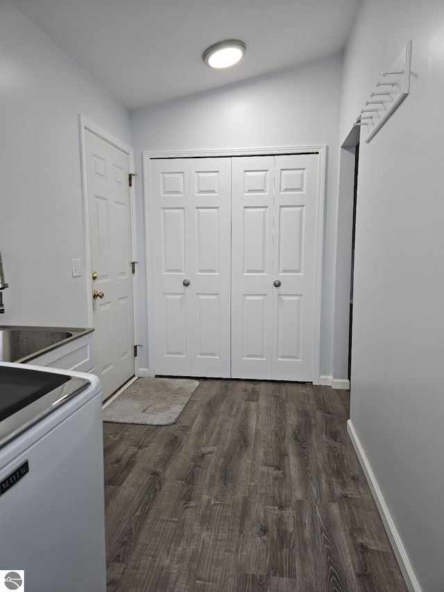 laundry room featuring laundry area, baseboards, and dark wood-style flooring