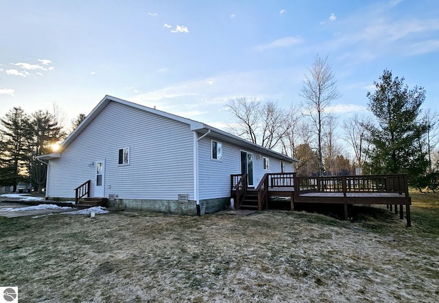 view of side of home featuring entry steps and a wooden deck