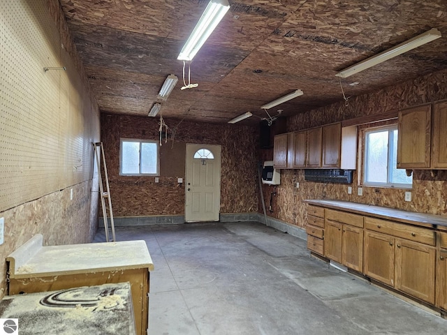 kitchen featuring plenty of natural light, brown cabinets, and concrete floors