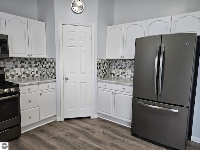 kitchen featuring stainless steel appliances, backsplash, dark wood-style flooring, and white cabinetry