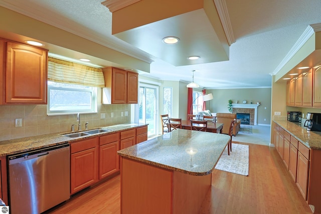 kitchen featuring ornamental molding, a sink, light stone counters, a fireplace, and dishwasher