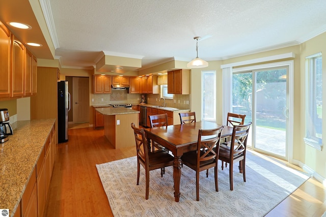 dining space with baseboards, ornamental molding, recessed lighting, light wood-style flooring, and a textured ceiling