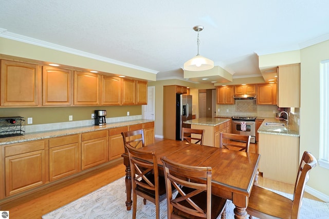 dining room featuring baseboards, light wood-style floors, and crown molding