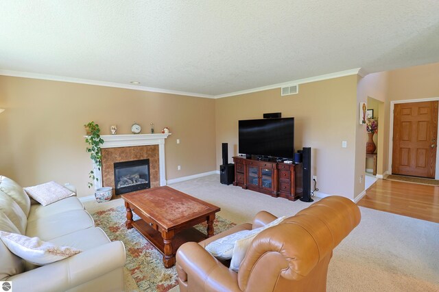 living area with visible vents, a textured ceiling, crown molding, and baseboards