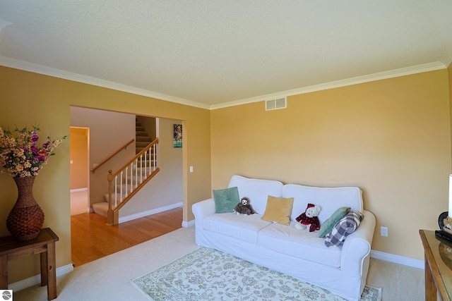 living area with stairway, baseboards, visible vents, and ornamental molding