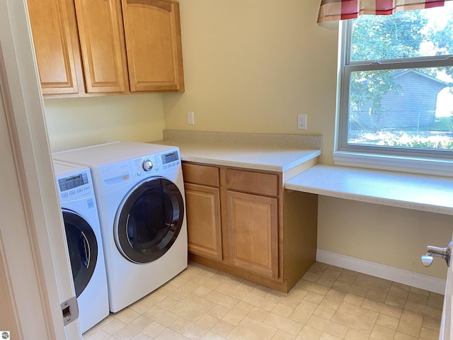 laundry room featuring baseboards, cabinet space, and independent washer and dryer