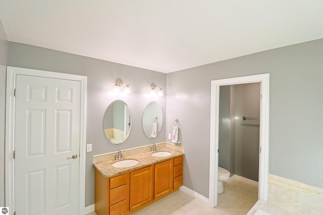 full bathroom with tile patterned floors, double vanity, toilet, and a sink