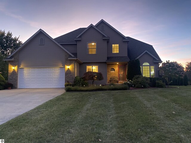 traditional-style home with driveway, roof with shingles, a front lawn, a garage, and brick siding