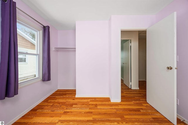 unfurnished bedroom with baseboards and light wood-type flooring