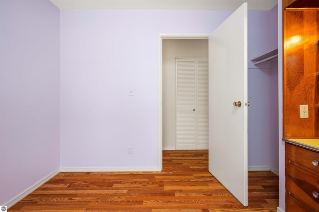 unfurnished bedroom featuring baseboards and wood finished floors