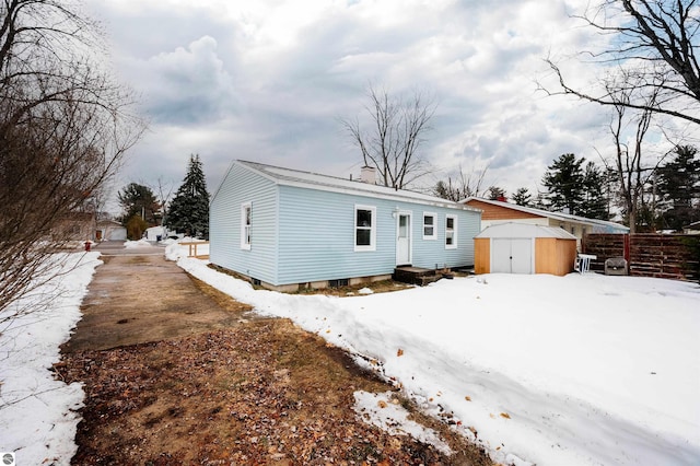 view of front of home featuring a storage unit, an outdoor structure, and fence