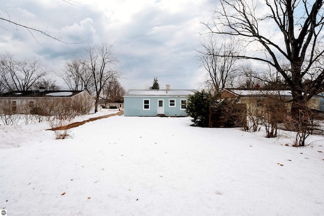 view of snow covered rear of property