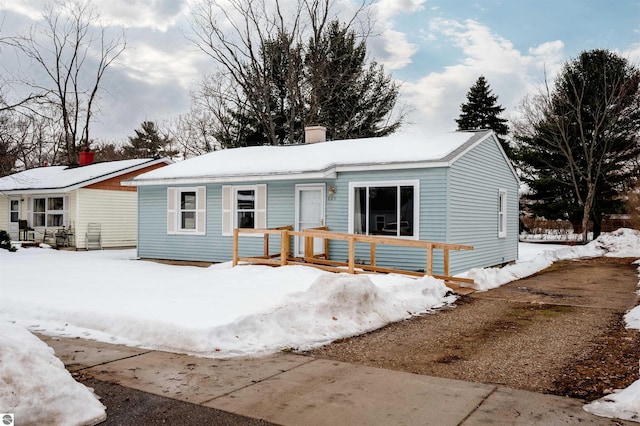 single story home with covered porch and a chimney