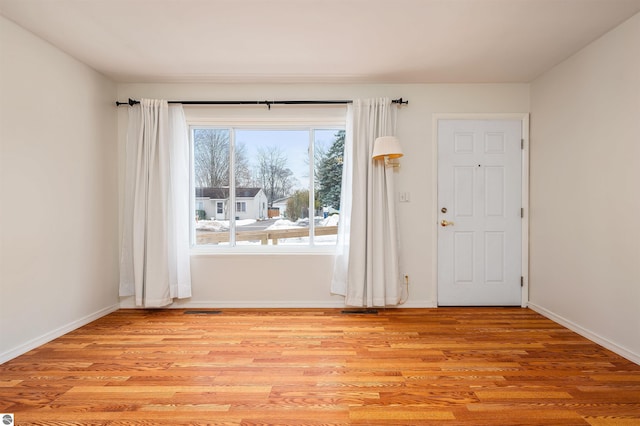 empty room with baseboards and light wood finished floors