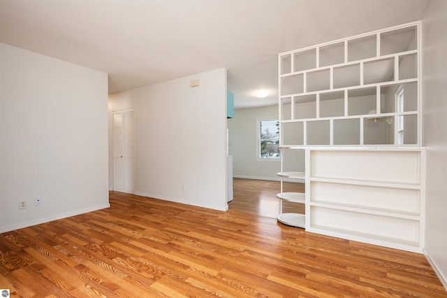 unfurnished room with baseboards and light wood finished floors