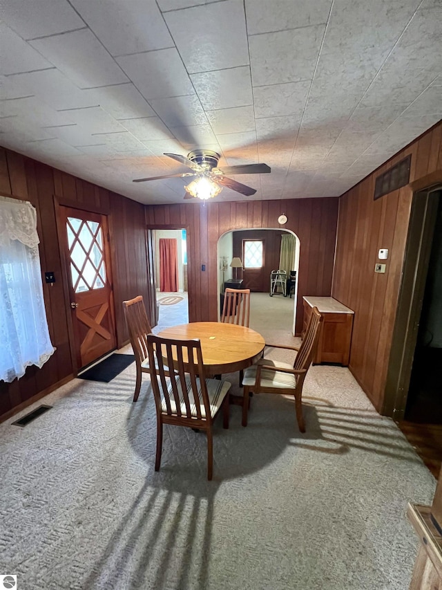 dining room featuring arched walkways, visible vents, and carpet