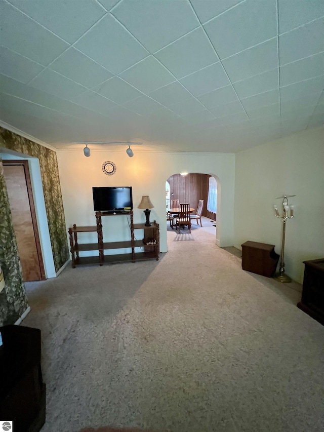 unfurnished living room featuring a paneled ceiling and arched walkways