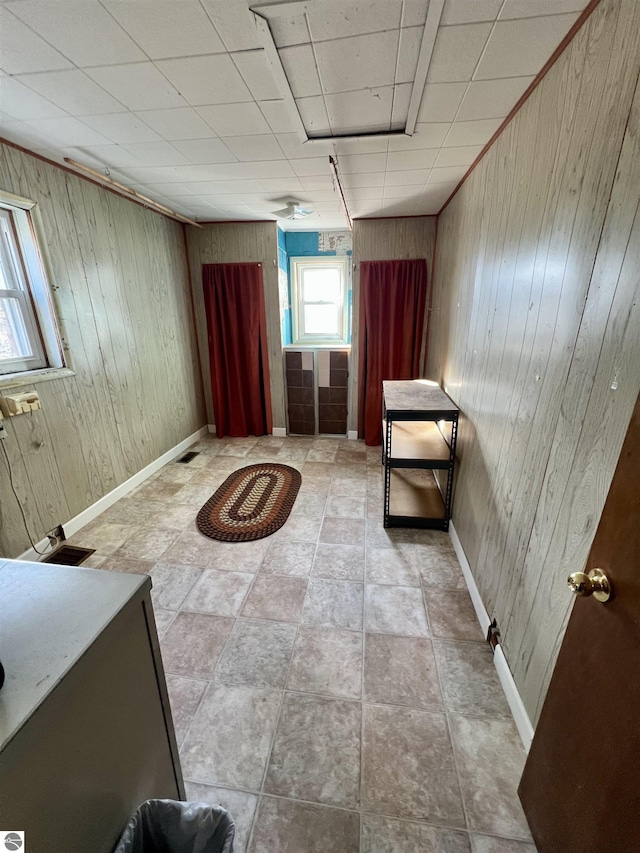 interior space featuring baseboards and wood walls