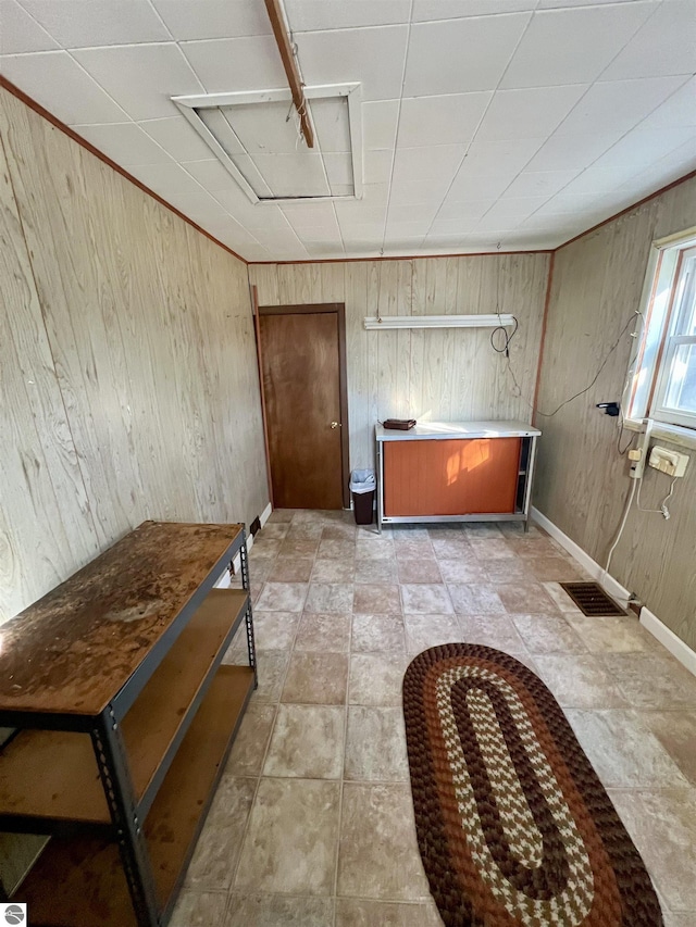 interior space featuring visible vents, baseboards, and wooden walls