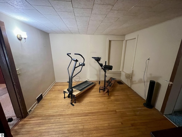 workout area with light wood-style flooring and baseboards