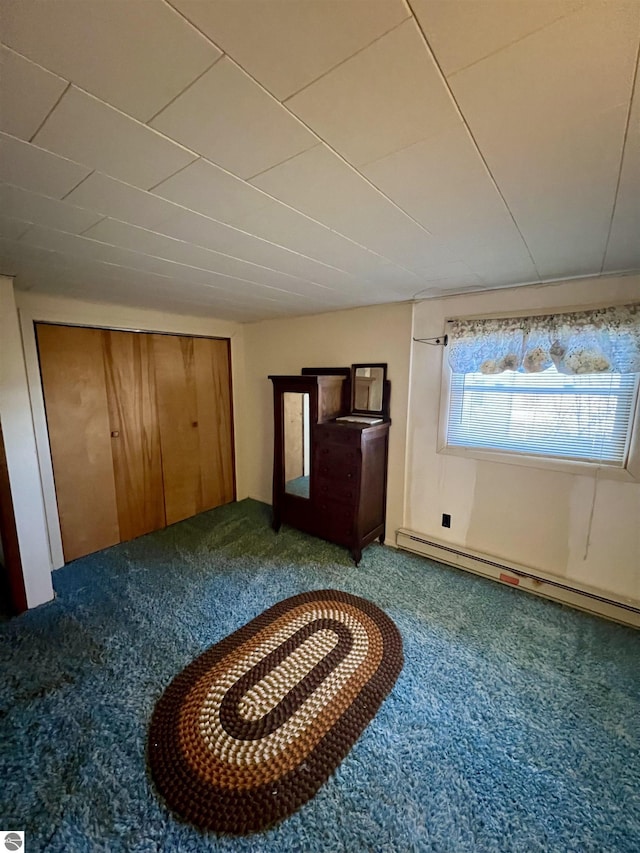 unfurnished bedroom featuring carpet and baseboard heating