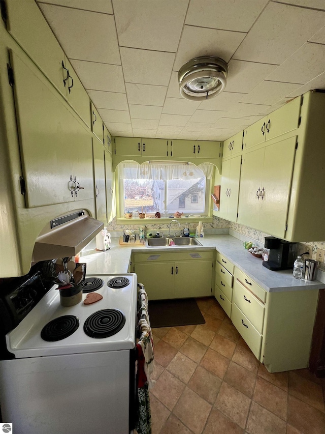 kitchen with white electric stove, light countertops, and a sink