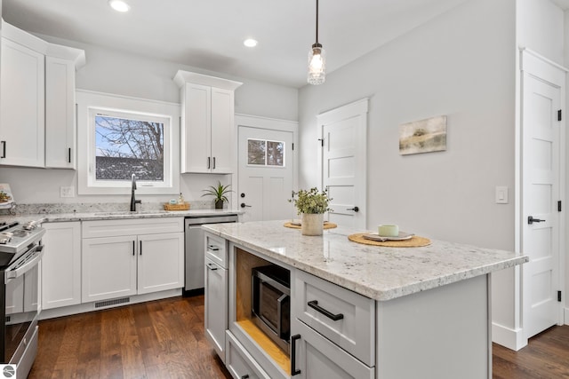 kitchen with visible vents, appliances with stainless steel finishes, dark wood-type flooring, and a sink