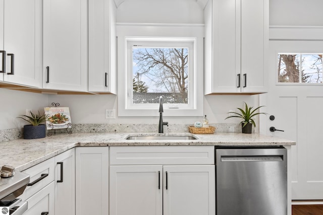 kitchen featuring a sink, light stone countertops, stainless steel dishwasher, and white cabinetry