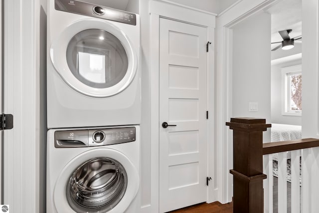 washroom featuring laundry area, stacked washer and dryer, and a ceiling fan