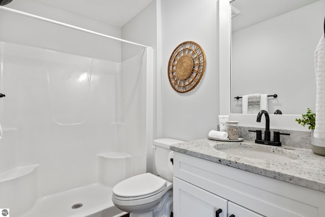 bathroom with vanity, toilet, and a stall shower