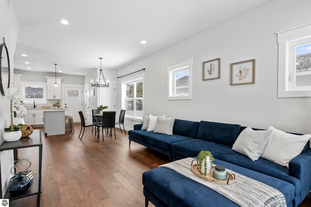 living area featuring a notable chandelier, recessed lighting, and dark wood-style flooring