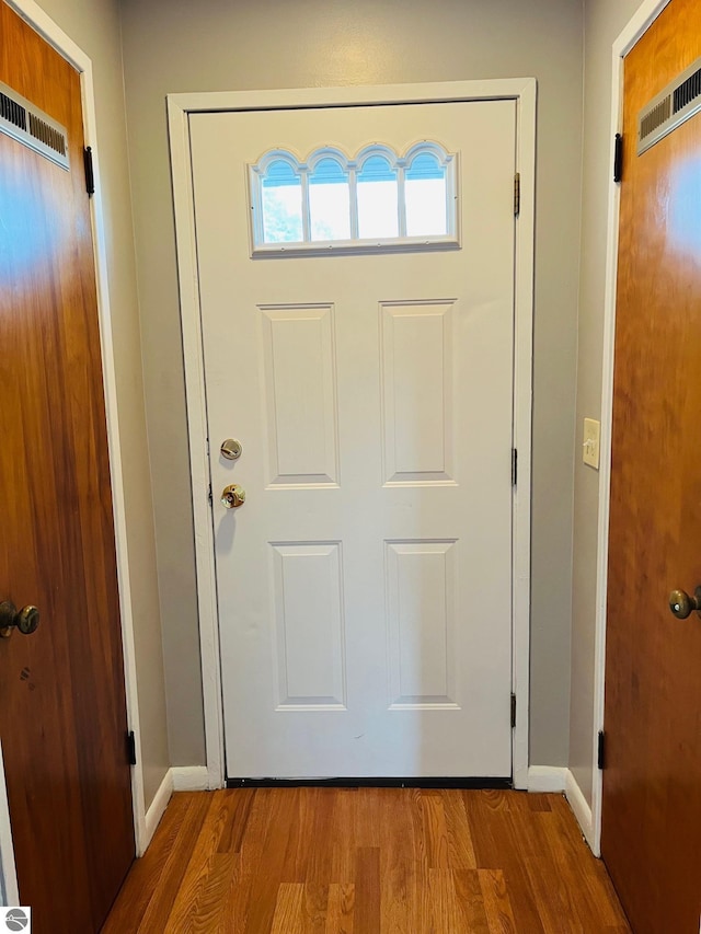 entryway featuring visible vents, wood finished floors, and baseboards