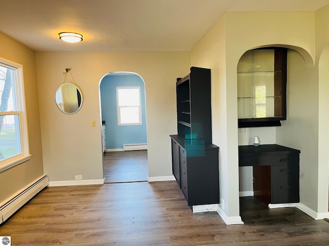 interior space featuring baseboards, dark wood-style flooring, baseboard heating, and a baseboard radiator