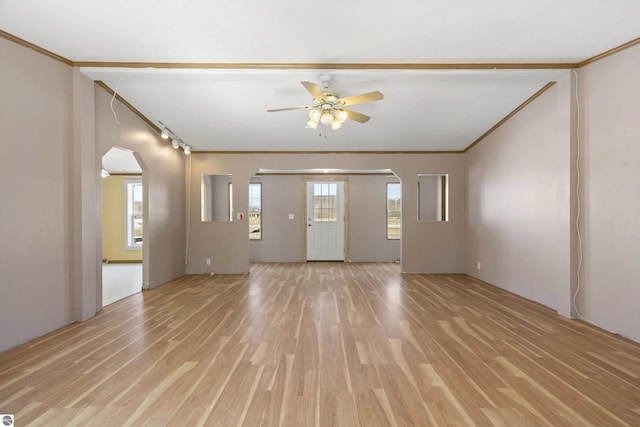 unfurnished living room with arched walkways, light wood finished floors, and ornamental molding