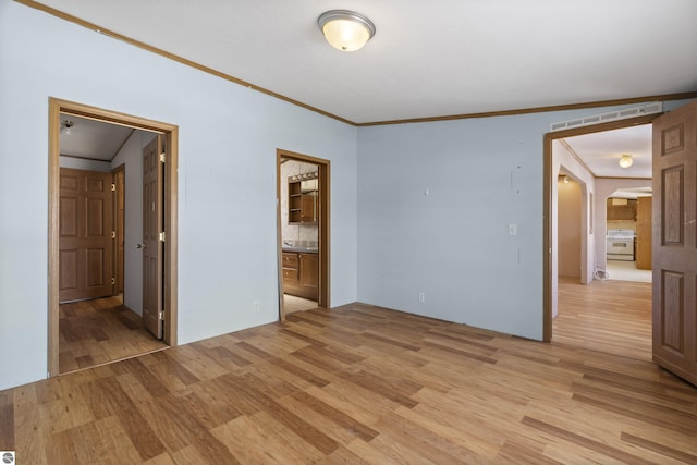 unfurnished bedroom with light wood finished floors, visible vents, ensuite bathroom, and ornamental molding