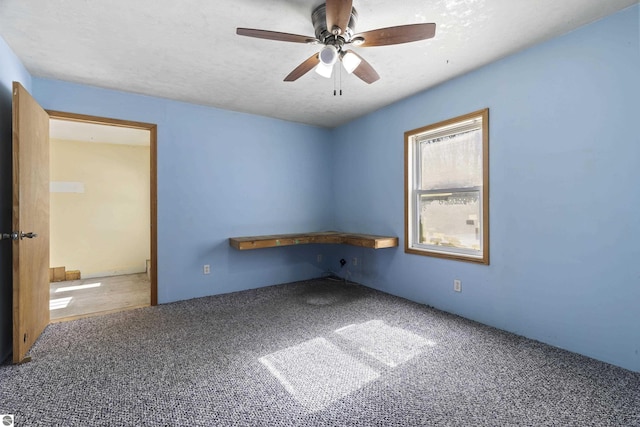 empty room with a ceiling fan, carpet, and a textured ceiling