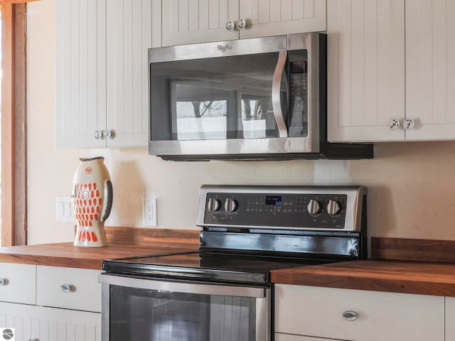 kitchen featuring white cabinets, appliances with stainless steel finishes, and wood counters