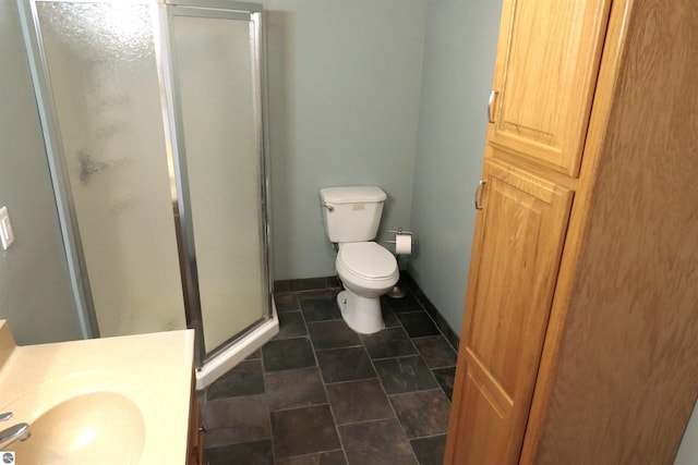 full bathroom featuring a shower stall, toilet, baseboards, and a sink