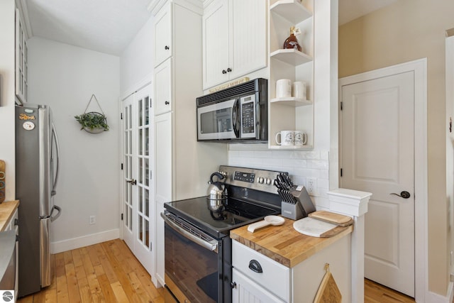 kitchen featuring backsplash, stainless steel appliances, white cabinetry, wood counters, and open shelves