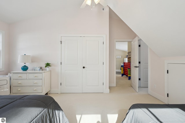 bedroom with lofted ceiling, light colored carpet, a closet, and baseboards