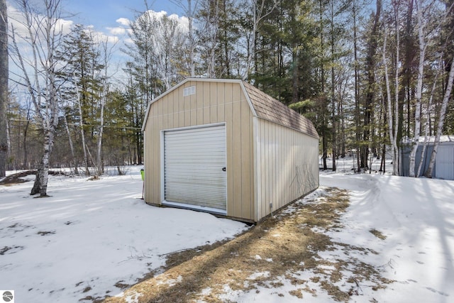 snow covered garage with a detached garage