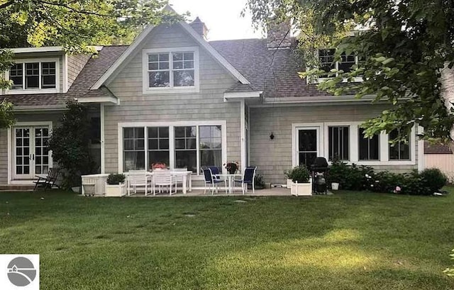 back of house with a patio area, french doors, a yard, and roof with shingles