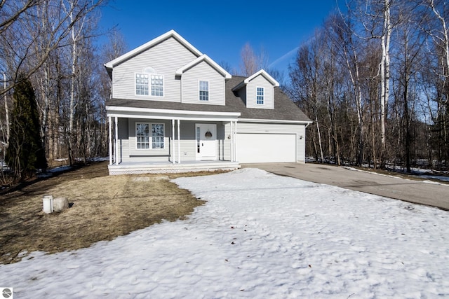 traditional-style house featuring a garage, covered porch, driveway, and a shingled roof